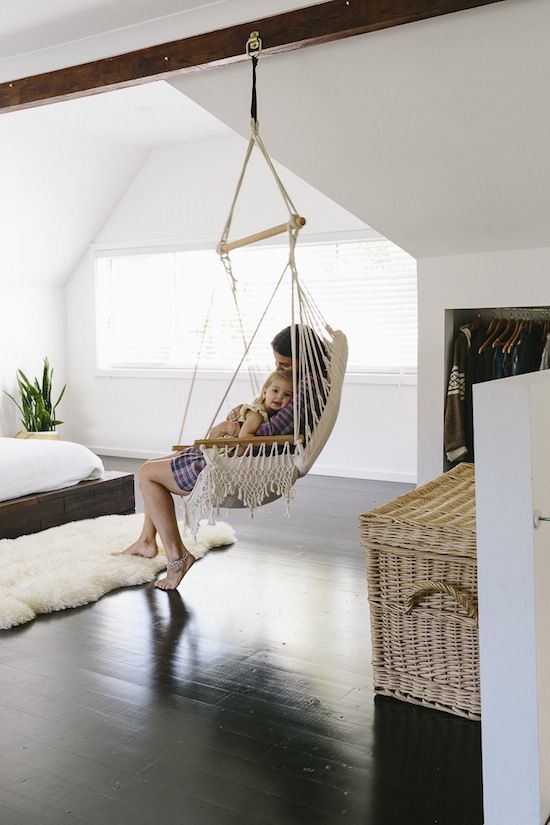 a laconic bedroom with a boho feel and relaxed vibes expressed by a hammock  chair and a wicker chest