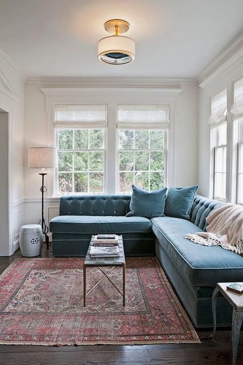 a mid-century modern space with a large muted blue velvet banquette seating