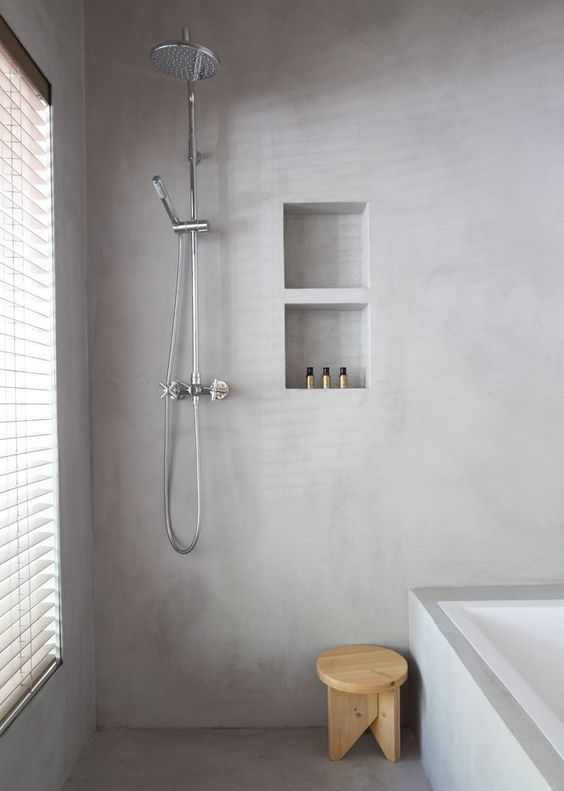 a minimalist bathroom with light grey plaster walls and floor looks very peaceful and welcoming