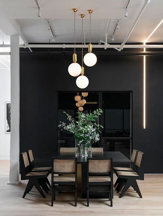 a moody dining space done with a cluster of pendant lamps and a neon tube light to make it more contemporary