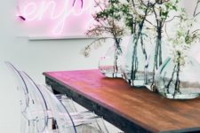 24 a modern dining space done with a pink neon light and acrylich chairs that contrast the wooden table