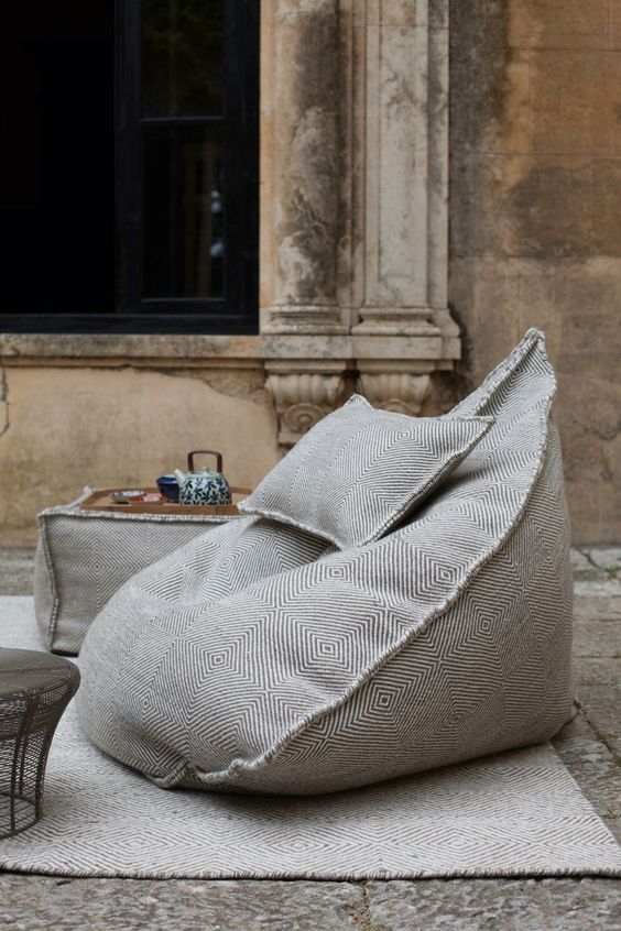 grey printed bean bag chairs and ottomans plus a rug to create a comfortable outdoor space