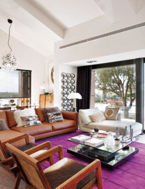 A bright and cozy mid century modern living room with a magenta rug for a colorful touch