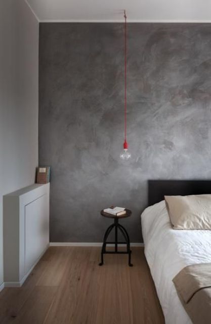 spruce up your simple industrial bedroom with a dark grey plaster wall behind the headboard
