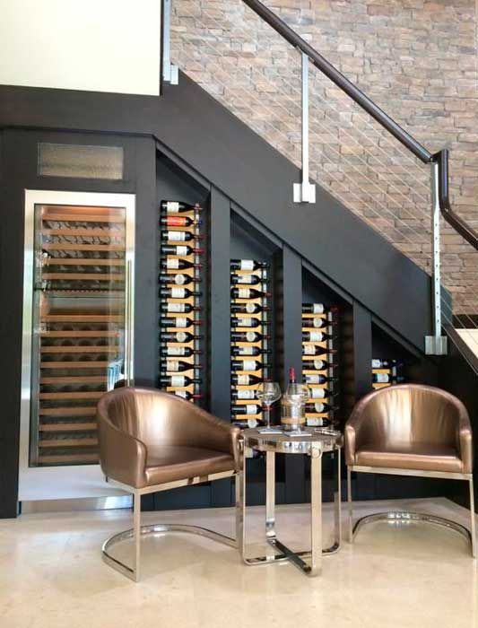 wine bottles on wall-mounted shelves and a special cooler plus a sitting space to have a drink here
