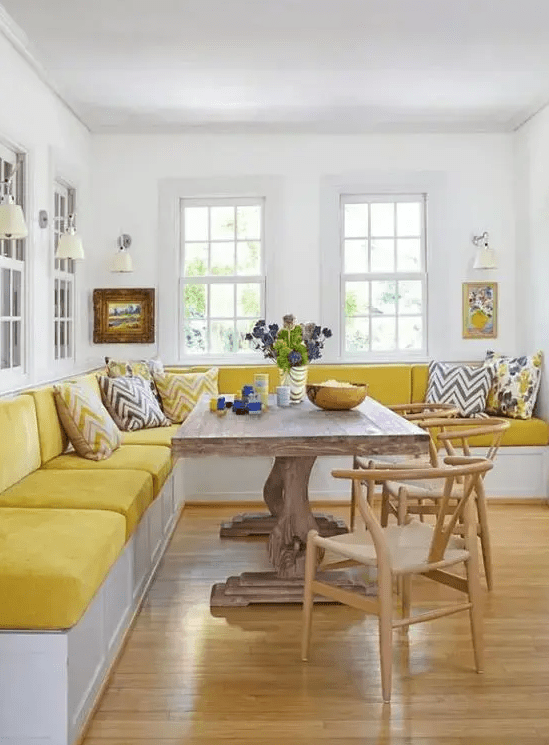 a colorful dining room with a bright yellow corner velvet banquette seating is a gorgeous space to have a meal