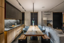 02 The kitchen and dining space are done in light-colored wood and dark greys for a contrast