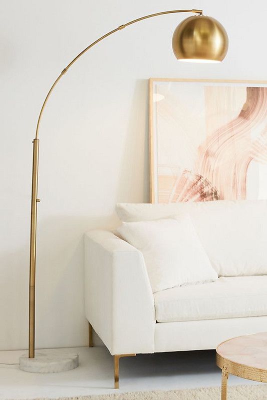 a brass arc lamp with a marble base is a chic and glam toouch that will fit many decor styles