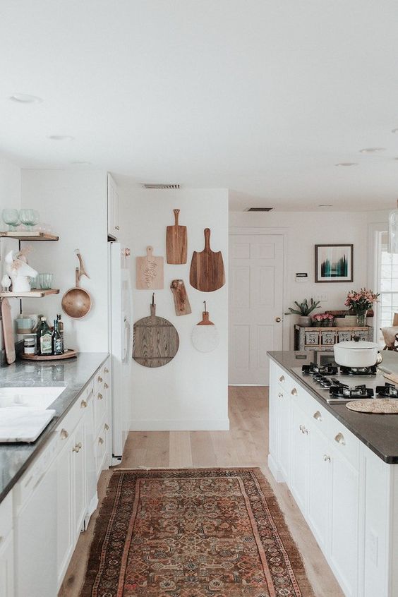 a coastal meets boho kitchen with a vintage boho rug, boards on the wall and neutral furniture