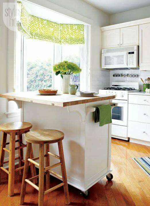 a mobile white kitchen island with a wooden countertop and much storage plus an eating space