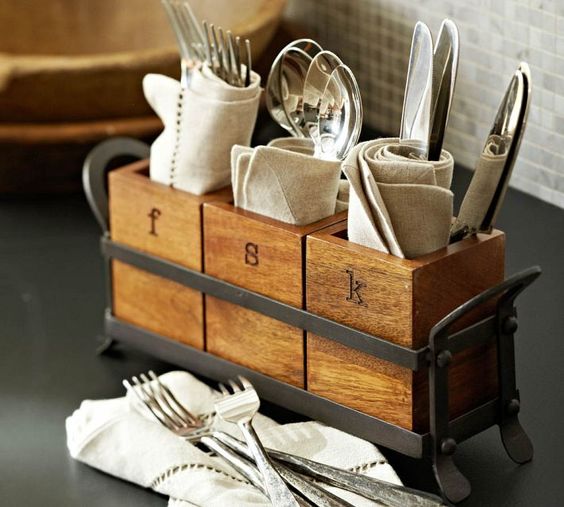 An industrial kitchen caddy with cutlery holders of wood and a metal frame in grey