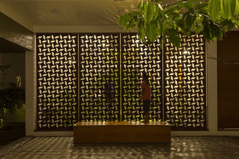 The perforated facade casts patterns across the home’s interior