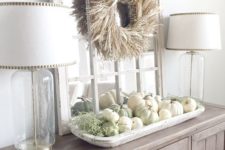 03 a farmhouse buffet with a corn husk wreath over the table and a tray with white and green pumpkins plus moss