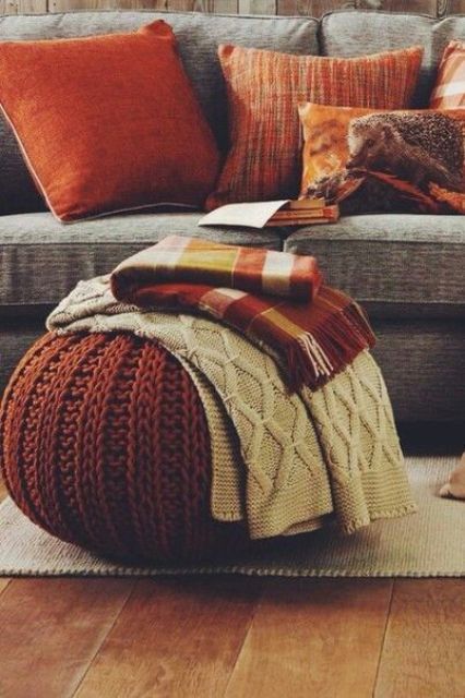 A touch of traditional fall color   rust is a great idea for any space, here it's added with pillows and a knit ottoman