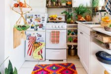 04 a colorful kitchen with a colorful textiles, a macrame fruit holder and lots of potted greenery