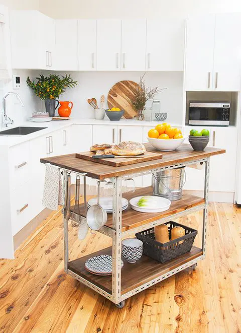 a mobile industrial kitchen island of metal and wood with two shelves and hooks and holders for an edgy touch