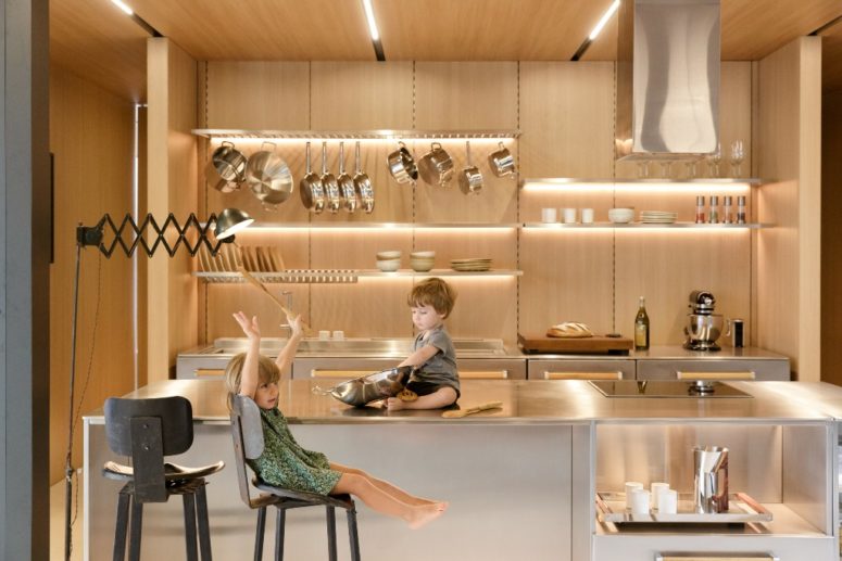 The kitchen shows off lit up shelves and metal surfaces, it looks ultra-modern and shiny