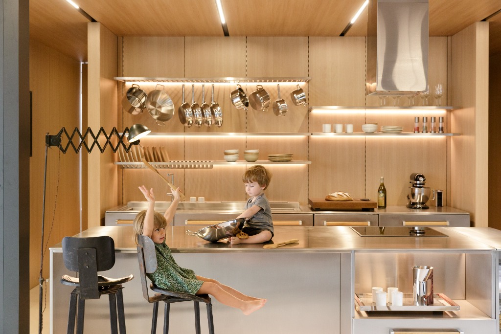 The kitchen shows off lit up shelves and metal surfaces, it looks ultra modern and shiny