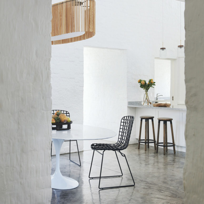 There's a dining zone next to the kitchen, with a modern table and wire chairs plus a statement lamp over them