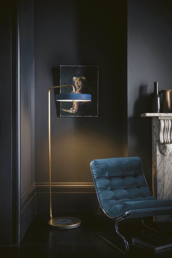 a chic floor lamp with aged copper and a narrow navy lampshade is a refined touch to your space