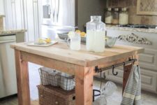 05 a rustic wooden kitchen island on casters with holders and hooks plus a storage space underneath