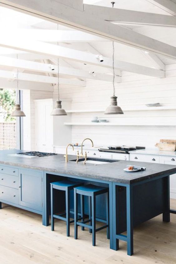 A trendy two toned kitchen look can be achieved with a large kitchen island of a different color like here   a bold blue one