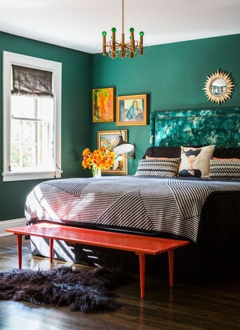 Bold emerald walls make up a cool colorful space and artworks and furniture continue it