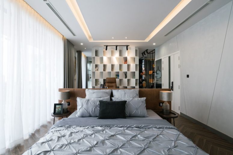 The sleeping space is divided with a large leather headboard from the other spaces