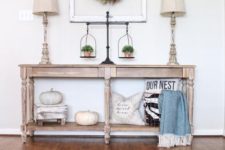 06 a fall farmhouse console table with white pumpkins, pillows and greenery in pots