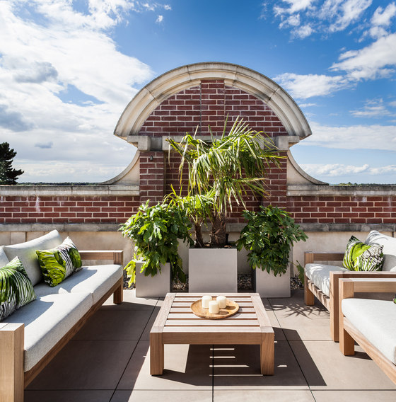 The terrace features a central sitting space with potted plants and contemporary furniture
