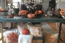 07 a bold fall console in teal with faux pumpkins, fall leaves, cotton and wire baskets with pillows