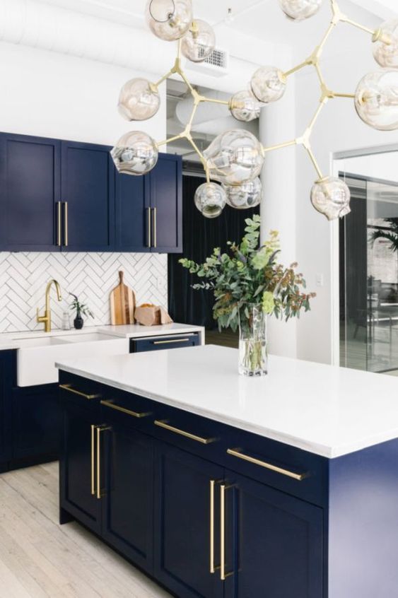 a chic kitchen in white, navy as a secondary color and gold for elegant touches