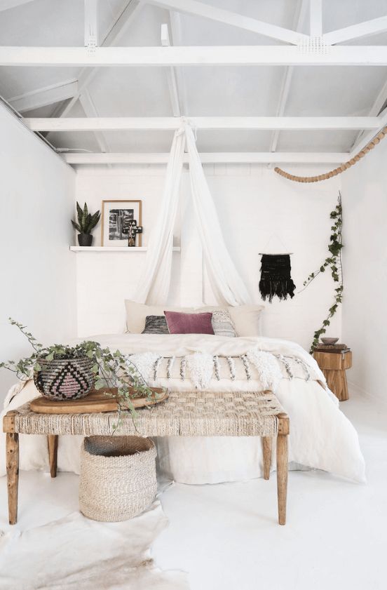 a woven bench, a basket and a woven planter, a fringe blanket and some greenery for a white boho space