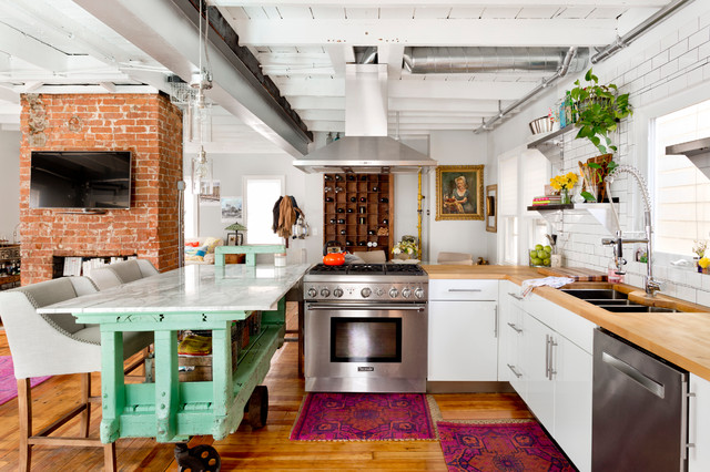 bold printed rugs, an aqua kitchen island and some potted greenery for a strong boho feel