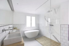 08 The bathroom is done with tow sinks, an oval bathtub and a minimalist shower done with marble and wood