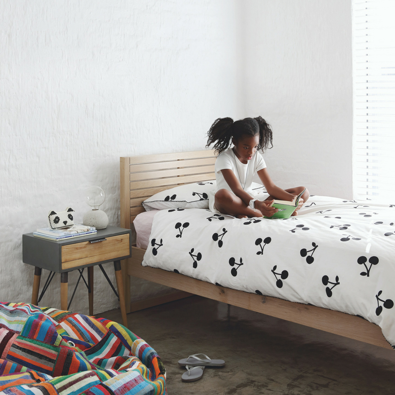 The kid's bedroom is spruced up with a colorful bean bag and simple wooden furniture