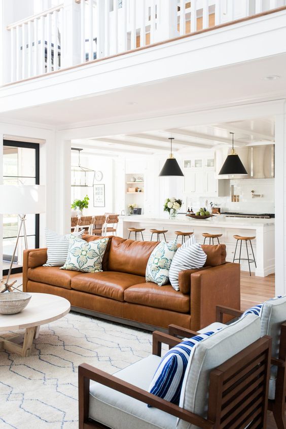 a brown leather couch as the main point on this large open layout, it makes statement with color