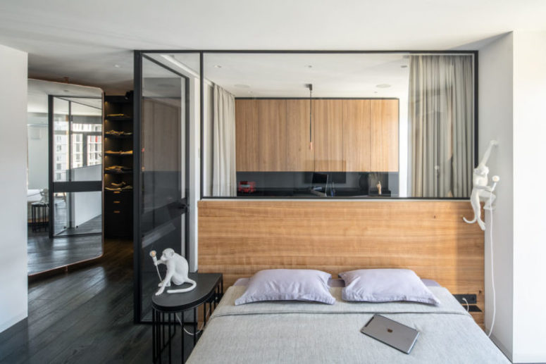 The bedroom is separated from the rest of the spaces with glass partitions