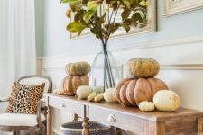 09 a vintage farmhouse console table with chevron baskets, natural pumpkins stacked on each other and fall leaves in a vase
