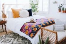 09 a wicker bench at the foot of the bed, colorful bedding and large tassels hanging