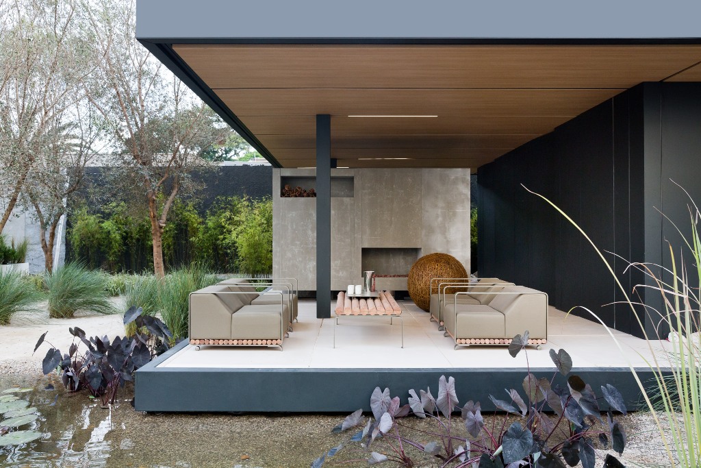 There's a roofed terrace with a fireplace, chairs and a table for inviting family and friends