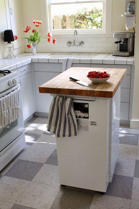 a portable dishwasher kitchen island with a butcher block countertop and holders is a functional option