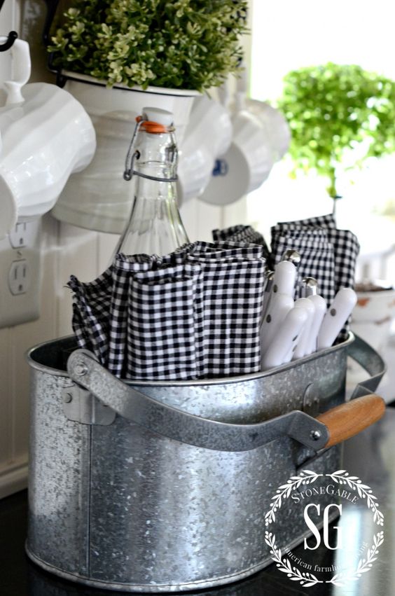 A rustic kitchen caddy of galvanized steel for cutlery and bottles