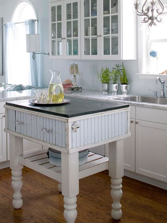 a farmhouse kitchen island in white and blue with drawers and a shelf for a coastal farmhouse kitchen