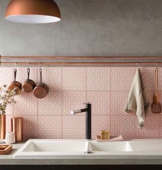 a pink printed tile backsplash spruced up with copper touches for a stylish look