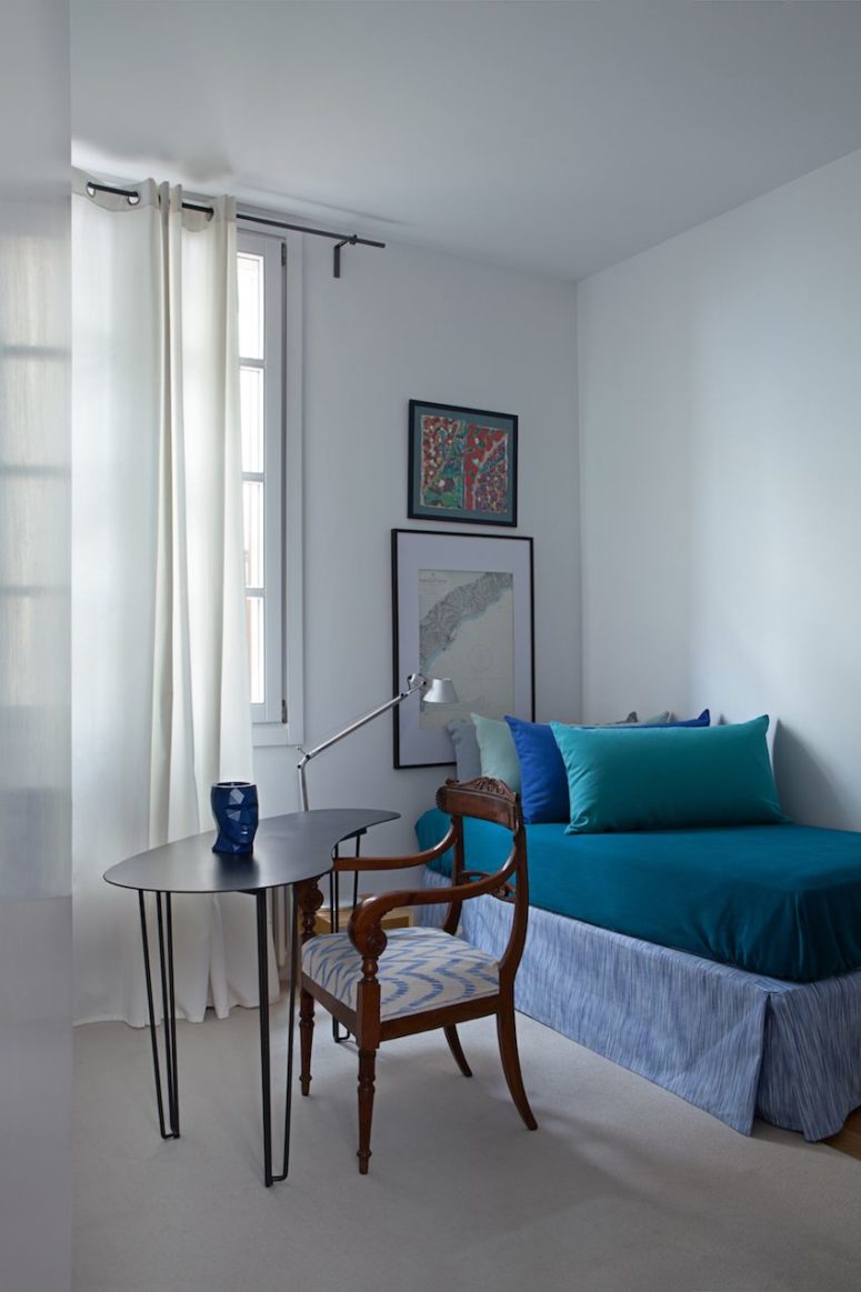 The guest bedroom features a comfy daybed, artworks and a vintage chair plus a modern desk