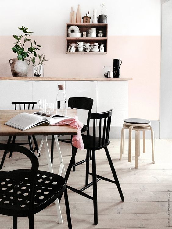 a blush kitchen backsplash and white cabinets are highlighted with black furniture
