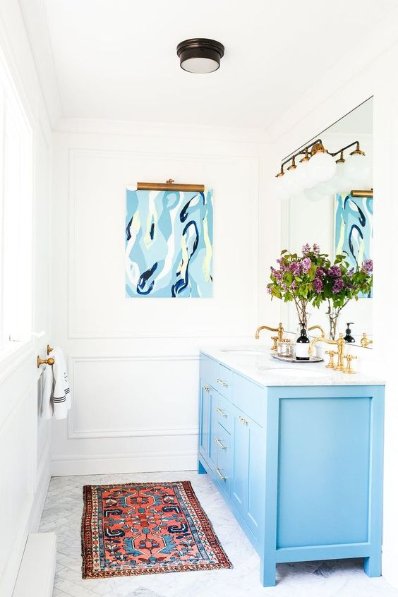 a blue bathroom vanity plus brass fixtures create a chic and refined feel in the bathroom