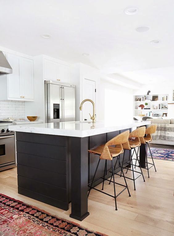 a contrasting black kitchen island with a sleek white countertop to connect it to the cabinets