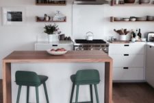 14 a minimalist waterfall kitchen island in white with a wooden countertop and colorful stools